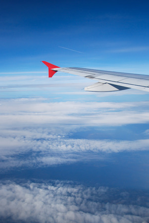 wing of plane and blue sky taken from window of planeの写真素材