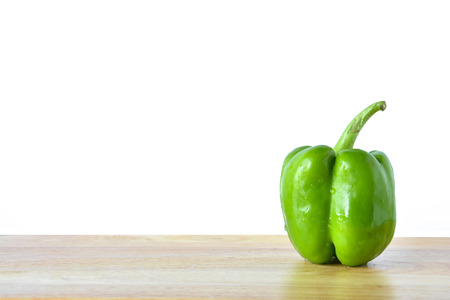 Fresh green pepper on wooden table isolated on white backgroundの写真素材