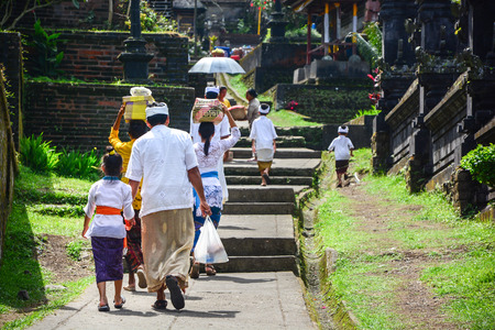 Unidentified Balinese people walk in traditional dress in Pura Besakih on January 17 2013 in Bali Indonesia.の写真素材