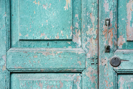 Old green weathered door with handle and lock