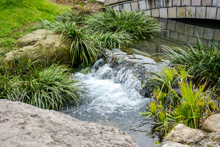Small waterfall over rocks in Chinese gardenの写真素材