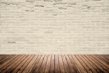 Old interior room with abstract light beige brick wall pattern and brown wood floorの写真素材