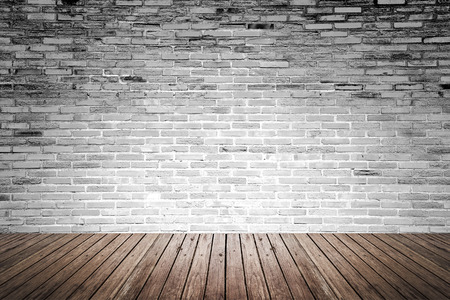 Old interior room with broken gray brick wall and grunge wood floor textureの写真素材