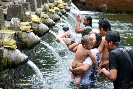 BALI INDONESIA  JANUARY 17: Worshippers make an offering at the Tirta Empul Temple on January 17 2013 in Bali Indonesia. They believe that water from the spring is holy and has the healing power.のeditorial素材