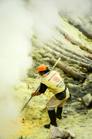 KAWAH IJEN INDONESIA  JANUARY 22 2013 : Miner collect sulfur sulphur in fumes of toxic volcanic gas from the sulfur mines in the crater of the active volcano of Kawah Ijen East Java Indonesia.のeditorial素材