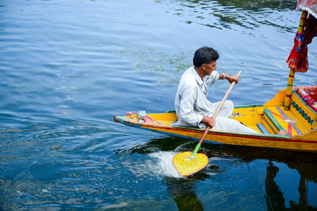 SRINAGAR, INDIA - JULY,11, 2014 : Unidentified local people row the Shikara, a small boat for transportation in Dal lake of Srinagar, Jammu and Kashmir state, Indiaのeditorial素材