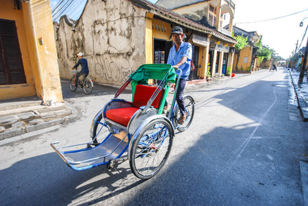 HOI AN, VIETNAM - OCTOBER 24, 2012 : Unidentified man riding a traditional cyclo in Hoi An, Vietnamのeditorial素材