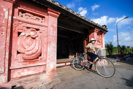 HOI AN, VIETNAM - OCTOBER 24, 2012 : Unidentified woman ride the bicycle at Japanese bridge in Hoi An, Veitnam. のeditorial素材