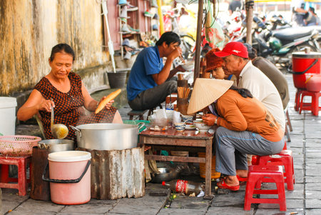 HOI AN, VIETNAM - OCTOBER 24,2012 : Vietnamese people in street food cafe on sidewalk at Hoi An ancient town of Vietnamのeditorial素材