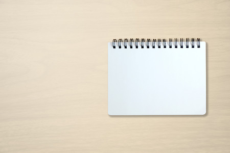 Blank page of notebook on beige office wooden table. use for background in business concept.の写真素材