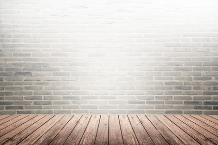 Old interior room with broken dark brick wall and grunge brown wooden floor texture with light on topの写真素材