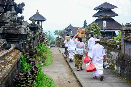 BALI, INDONESIA - JANUARY 17, 2013 : Unidentified Balinese people walk in traditional dress in Pura Besakih, one of tourist attractions in Bali, Indonesia.のeditorial素材
