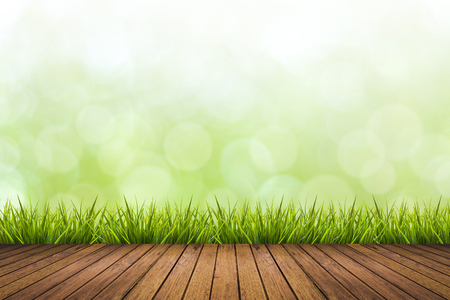 Fresh spring grass with green nature blurred background and wooden floor, use for natural spring conceptの写真素材