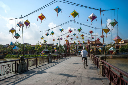 HOI AN, VIETNAM, OCTOBER 24, 2012 : Unidentified biker rider passing the bridge and decorating lamps over Hoai river in Hoi An ancient town, a World Heritage Site by UNESCO in Quang Nam, Vietnamのeditorial素材