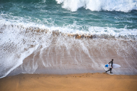 surfer man on the beach with turquoise-white water wave in the sea from top view at Bells beach, Torquay, Australia.のeditorial素材