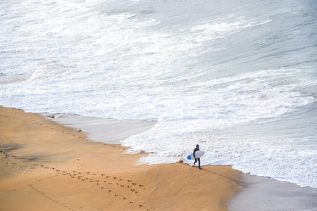 surfer man on the beach with white water wave in the sea at Bells beach, Torquay, Australia