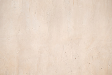 closeup surface detail of old light beige grunge stucco concrete wall, abstract rough texture for background or backdrop in architecture and structure conceptsの写真素材