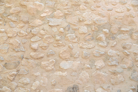 old beige stone wall pattern background, abstract grunge texture of pebble rock - use for architectural material conceptsの写真素材