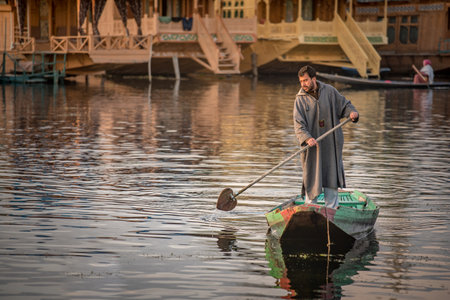 SRINAGAR, INDIA - APRIL 9, 2017 : Lifestyle of Kashmiri local people rowing wooden boat in Dal lake, a famous tourist attraction of Srinagar, Jammu and Kashmir state, North India.のeditorial素材