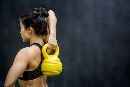 Young Asian woman doing exercise with kettle bell, healthy lifestyle conceptsの写真素材