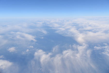 Aerial view of white clouds in the blue sky, Beautiful view from airplane windowの写真素材
