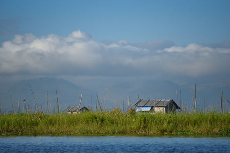 Traditional wood house with gable roof and green floating garden on Inle lake, located in the Nyaungshwe Township of Taunggyi, Shan State, Myanmarの写真素材