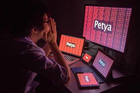 Young Asian male frustrated, confused and headache by Petya or Petrwrap ransomware attack on desktop screen, notebook and smartphone, cyber attack and internet security conceptsの写真素材