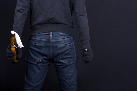 Protester or terrorist with Molotov cocktail as known as petrol bomb or bottle bomb. With black screen and lighter.の写真素材