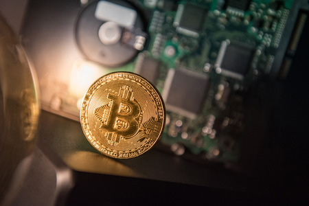 Bitcoin gold coin with blurry harddisk in the background. Worldwide cryptocurrency and online payment with digital currency conceptsの写真素材