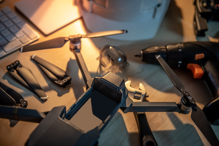 Drone maintenance with spare parts on the table. propeller, battery, remote control, and other fixing tools. Self inventive repairing drone or unmanned aerial vehicle (UAV) photography conceptsの写真素材