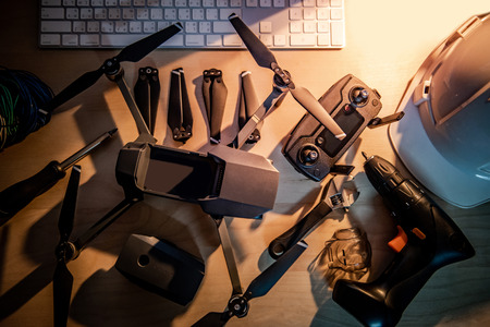 Drone maintenance with spare parts on the table. propeller, battery, remote control, and other fixing tools. Self inventive repairing drone or unmanned aerial vehicle (UAV) photography conceptsの写真素材