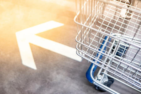 Shopping cart (trolley) over go forward arrowhead sign on the floor in supermarket or grocery store. Shopping lifestyle conceptの素材 [FY310107425841]