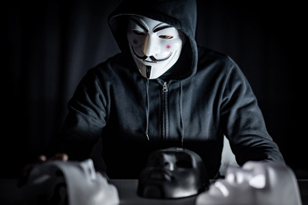 BANGKOK, THAILAND - SEPTEMBER 21, 2018 : Hoodie man wearing mystery mask choosing black or white masks on the table. Anonymous social masking. Major depressive disorder. Halloween conceptのeditorial素材