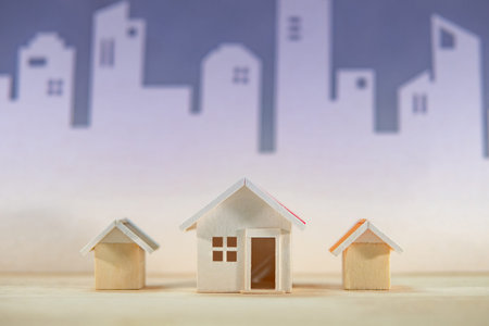 Real estate or property investment. Home design concept. Wooden house models on the table with city...