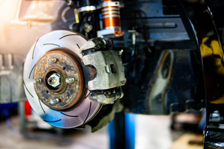 Disc brake and wheel bearing of racing car in auto repair garage. Automobile industry concept