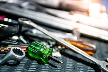 Screwdriver, wrench and other tools on the tray in car repair garage. Auto fixing equipment for mechanic.の写真素材