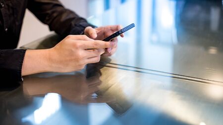 Mobile app for internet of things. Big data technology and cloud computing. Businessman hand texting message at bar counter in the cafe. Using smartphone for online shopping and internet banking.の写真素材