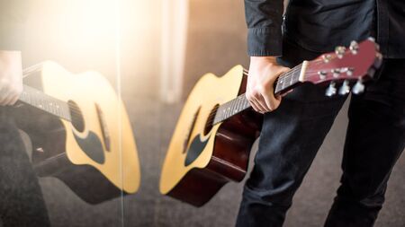 Male guitarist holding acoustic guitar. Playing string instrument conceptの写真素材