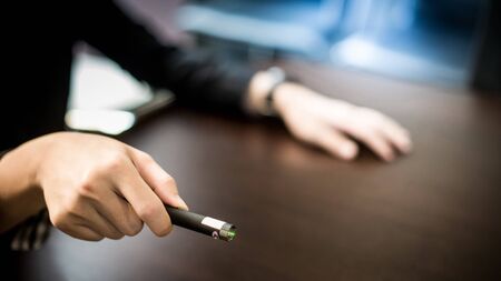 Male hand holding laser pointer in meeting room. Tool for business presentation. Teaching conceptの写真素材