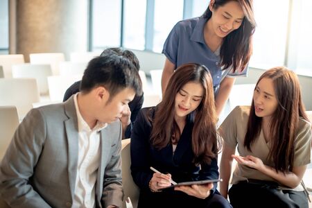 Business meeting and teamwork concept. Group of Asian colleagues discussing about project data report using digital tablet in conference room. Coworkers team sharing productive ideas in modern office.の写真素材