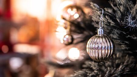 Silver Christmas ball on branch of Christmas tree with red copy space in the background. Decoration for festive season. Xmas and New Year celebration conceptの写真素材