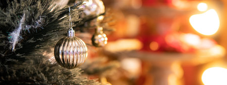 Silver Christmas ball on branch of Christmas tree with red copy space in the background. Decoration...
