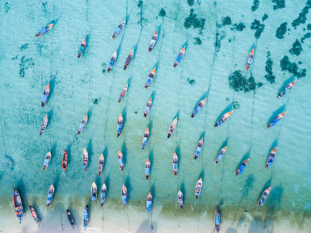 Stunning summer landscape. Aerial view of fishing long tail boat group in turquoise Andaman sea near beautiful white beach at Koh Lipe or Lipe island, Satun, Southern Thailand. Shot from droneの写真素材