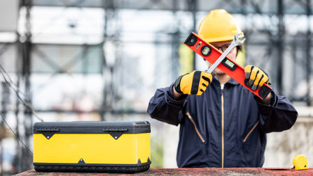 Male Asian mechanic or maintenance worker man wearing protective suit and helmet holding wrench and...