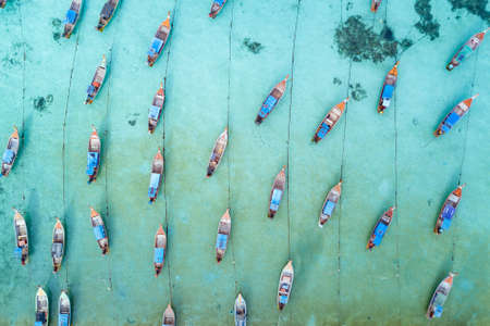 Stunning summer landscape. Aerial view of fishing long tail boat group in turquoise Andaman sea at Koh Lipe or Lipe island, Satun, Southern Thailand. Shot from droneの写真素材