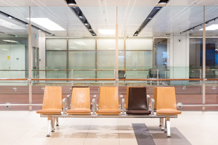 Empty passenger seat in Departure lounge. Wooden bench in Airport terminal. Transportation building
