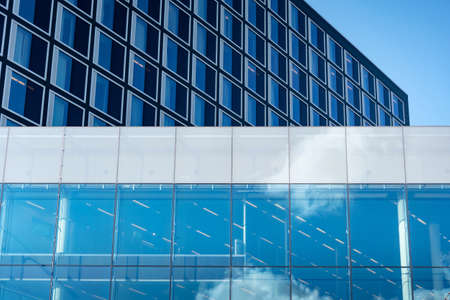 Modern glass building facade in business district against the blue sky. Architecture and construction conceptの写真素材
