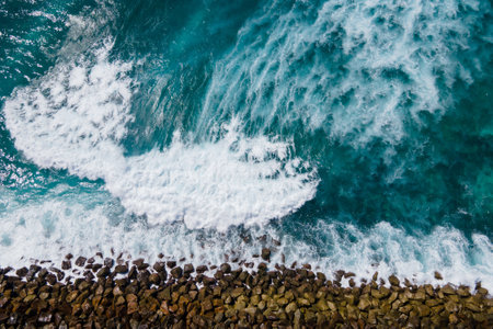 Aerial view of big turquoise wave reaching the breakwater in Maldives. Exotic tropical landscape from above. Summer holiday or vacation travel conceptsの写真素材
