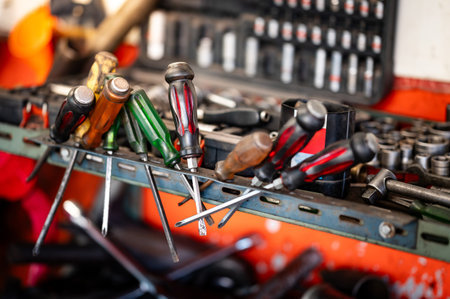 Group of screwdrivers and other mechanical work tools on workbench in garage workshop