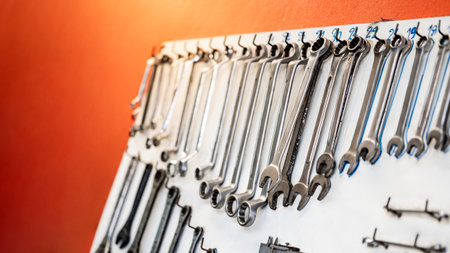 Set of metal combination wrench spanner hanging on storage board in garage workshop or auto repair shop. Auto mechanic tool for car fixing and maintenanceの写真素材